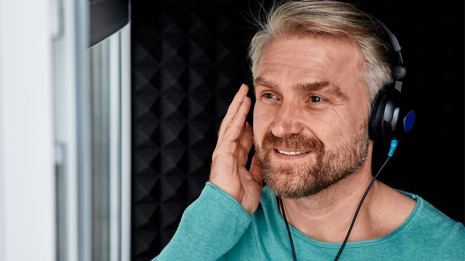 Homem a utilizar auscultadores durante Exame Auditivo