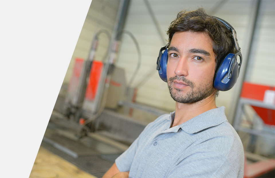Homme portant un casque antibruit dans un environnement de travail industriel