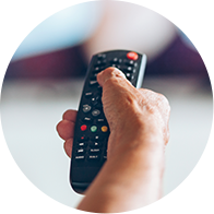 Une main tient une télécommande, prête à l'utiliser.