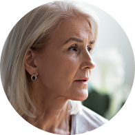 Profil latéral du visage d’une femme âgée avec des boucles d’oreilles élégantes et des cheveux gris.