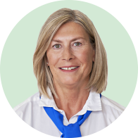 Femme aux cheveux blonds portant une chemise blanche et un foulard bleu.