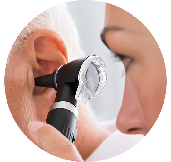 Un professionnel de la santé inspecte l’oreille d’une personne âgée à l’aide d’un otoscope.