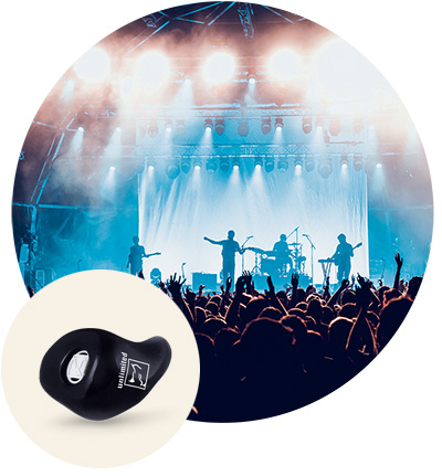 Ein In-dem-Ohr-Hörgerät von Philips liegt im Vordergrund, während im Hintergrund ein Konzert mit hell beleuchteter Bühne und jubelndem Publikum in einer grossen Halle stattfindet.