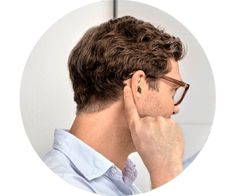 Ein junger Mann mit Oticon Zeal Hörgerät im Ohr von hinten. Man sieht das Hörgerät in seinem Ohr.