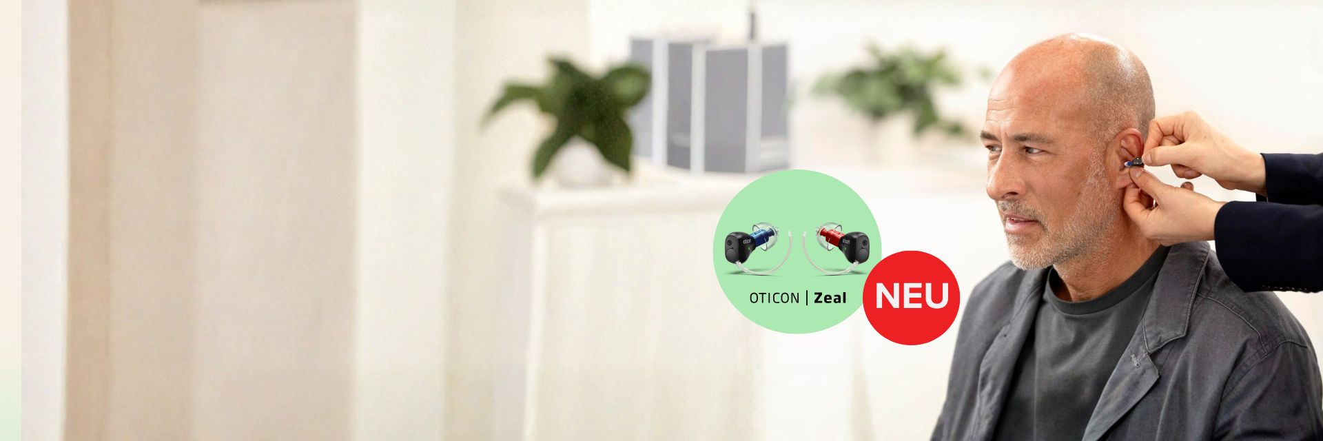 Ein Mann, dem das Oticon Zeal Hörgerät ins Ohr gesetzt wird.