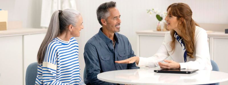 Moden kvinde og mand er til konsultation hos en hørespecialist. 