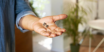 Høreapparater holdt i en åben hånd indendørs