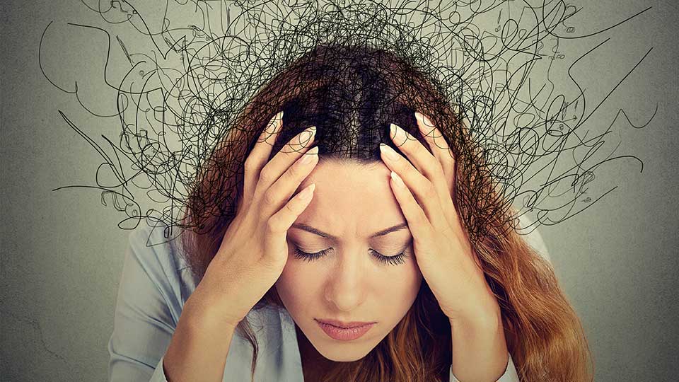 Kvinde med stress og mentale udfordringer illustreret med kaotiske streger omkring hovedet.