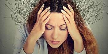 Kvinde med hænderne på hovedet, omgivet af krøllede linjer, der symboliserer stress eller overvældelse.