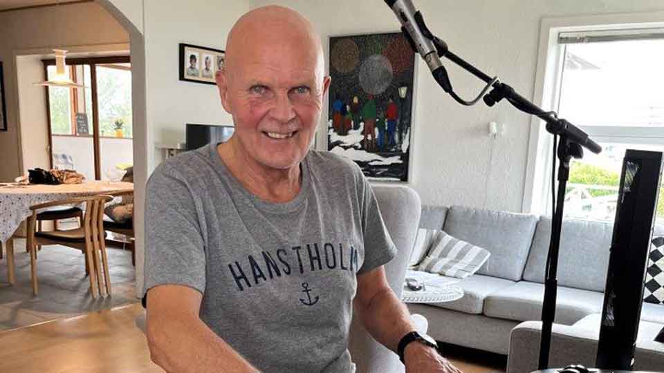Jens Lindby Sørensen ved mikrofonen i hjemlig stue - Audika Hørecenter