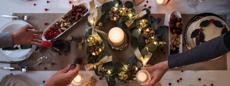 Julebord set oppe fra med levende lys og julekrans i midten.