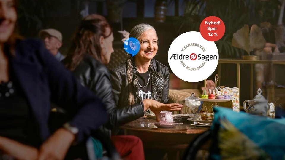 To personer sidder ved et bord og drikker te i en hyggelig café. Tekst: ’Vi samarbejder med Ældre Sagen. Nyhed! Spar 12 %.’ Der er farverige tekopper på bordet.