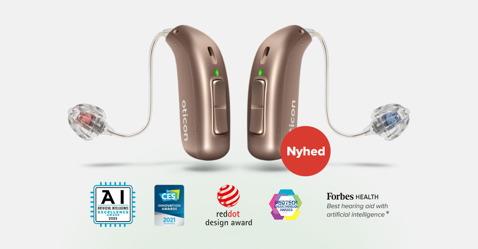 To høreapparater fra Oticon vises i en brun nuance. Kontekst: De er ledsaget af priser, herunder AI Excellence Award, CES 2021, reddot design award og Forbes Health. Tekst: 'Nyhed'.