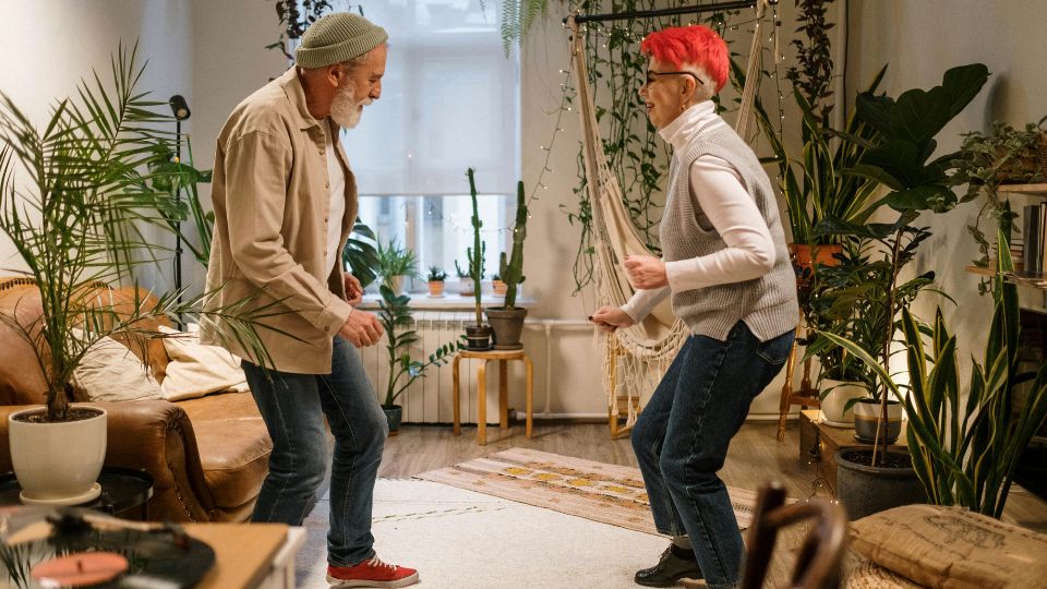 Dos personas bailan en el salón de una vivienda