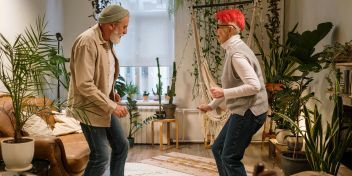 Dos personas bailan en el salón de una vivienda