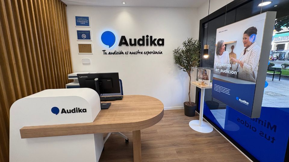 Audika Logroño, centro de cuidado auditivo con recepción moderna, slogan “Tu audición es nuestra experiencia’ y vista hacia el exterior.