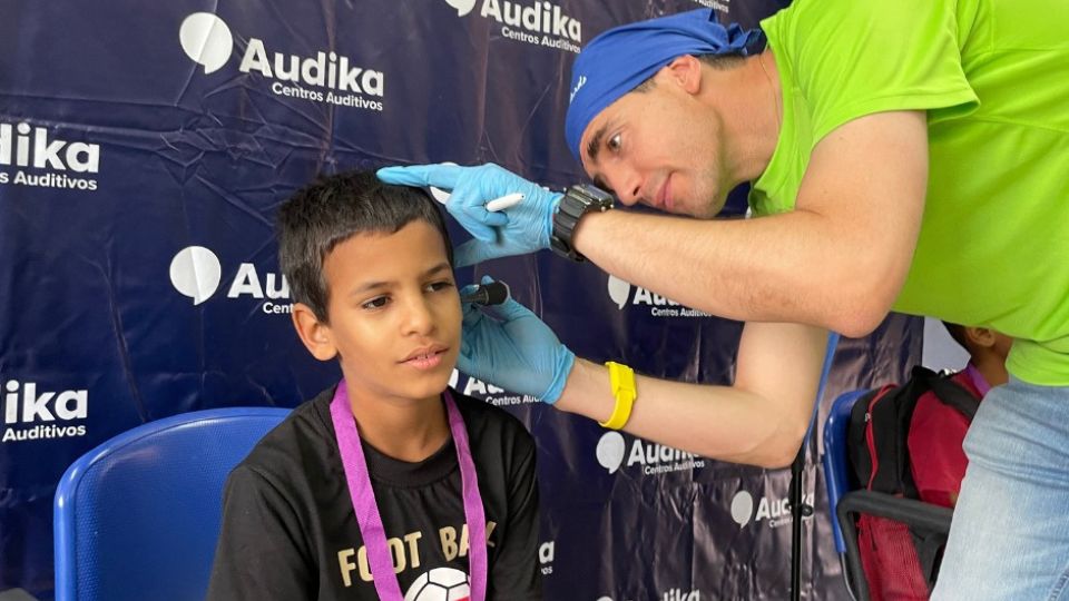Revisión auditiva a un niño durante una jornada solidaria de Audika Centros Auditivos.