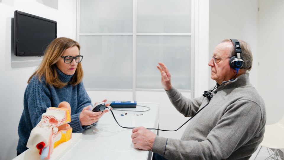 ajuste profesional de audífonos en una consulta de salud auditiva