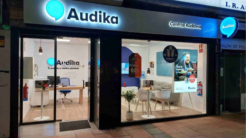 Centro auditivo Audika en León con fachada iluminada y vista del interior moderno y acogedor.