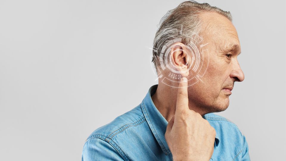 persona mayor señalando su oído con indicación de problemas de audición