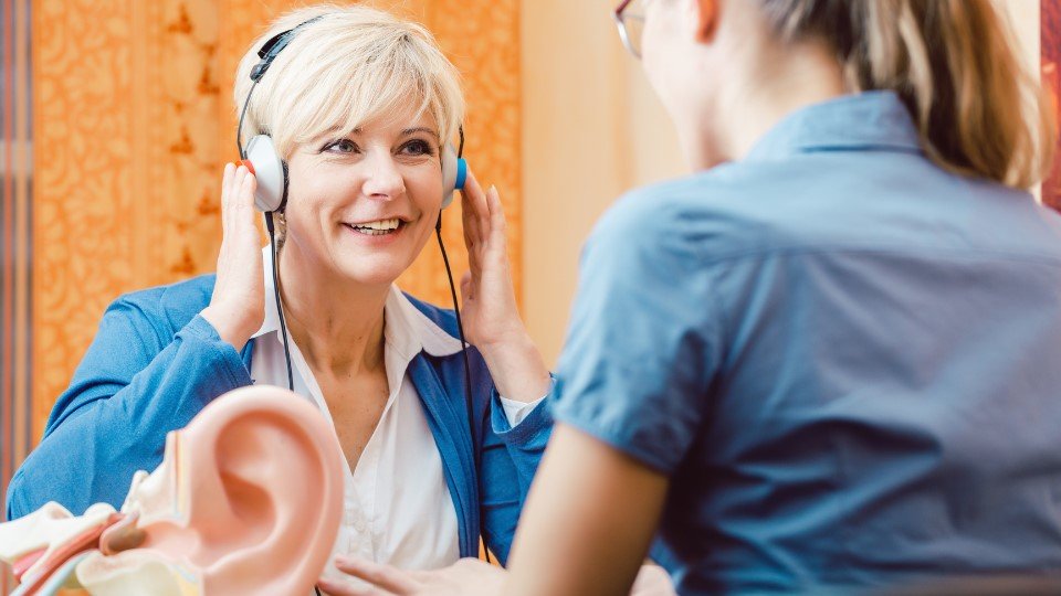 Prueba de audición con auriculares realizada por un especialista en salud auditiva.