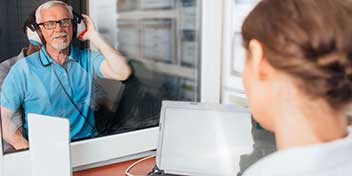 Prueba de audición realizada por un audioprotesista en una cabina insonorizada.