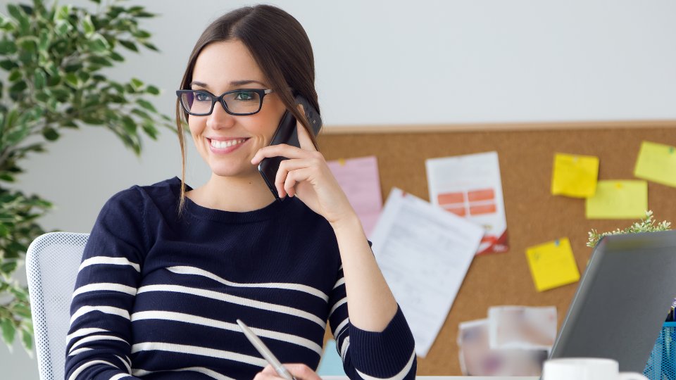 mujer joven hablando por teléfono en una oficina