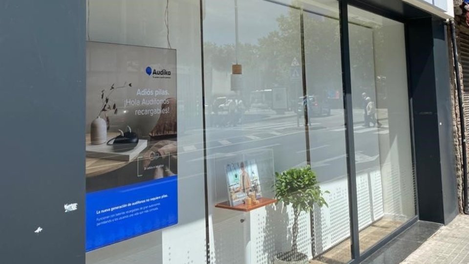 Nuevo centro auditivo en Terrassa con escaparate que destaca audífonos recargables y tecnología avanzada.