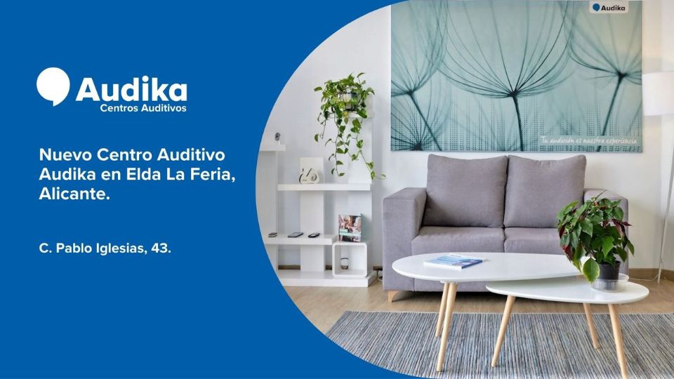 El diseño publicita el ’Nuevo Centro Auditivo Audika en Elda La Feria, Alicante’, ubicado en C. Pablo Iglesias, 43. Muestra un salón acogedor con sofá gris y decoración moderna.
