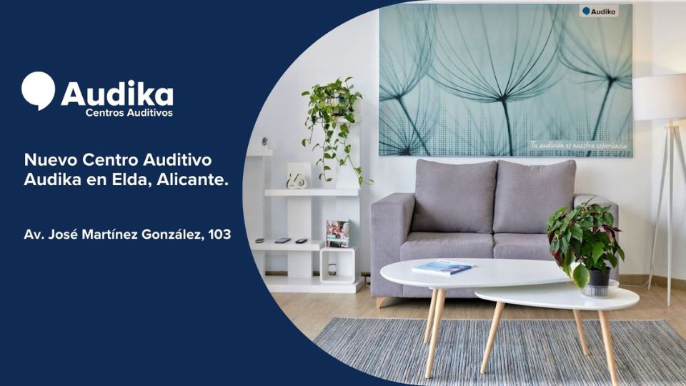 Nuevo Centro Auditivo Audika en Elda, Alicante. Ambiente moderno con sofá gris, mesas blancas, plantas, y decoración mural de diente de león. Dirección: Av. José Martínez González, 103.