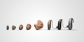 Audífonos modernos en diferentes tamaños y estilos (intraaurales y retroauriculares) alineados sobre un fondo blanco. Representan soluciones avanzadas de Audika para el cuidado auditivo.