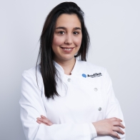 audioprotesista Elisa Marqués con uniforme blanco de una clínica auditiva