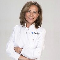 Manuela Arnau, Técnico Superior en Audiología Protésica, posando con bata blanca y brazos cruzados.