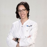 Audioprotesista en Albacete María Carmen López con bata blanca y brazos cruzados
