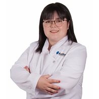 Audioprotesista Tamara Partal en Audika Reus con bata blanca y brazos cruzados