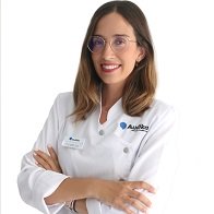 Audioprotesista de Audika Alicante Nerea Domínguez con bata blanca y brazos cruzados.