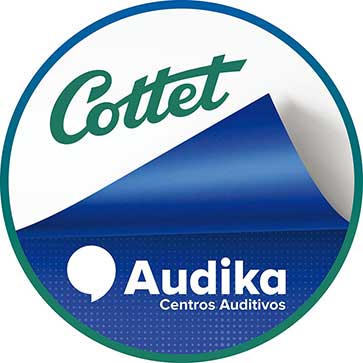 Un logotipo circular presenta ’Cottet’ en verde en la mitad superior. La mitad inferior muestra ’Audika Centros Auditivos’ en blanco sobre fondo azul, destacando su enfoque en soluciones auditivas.