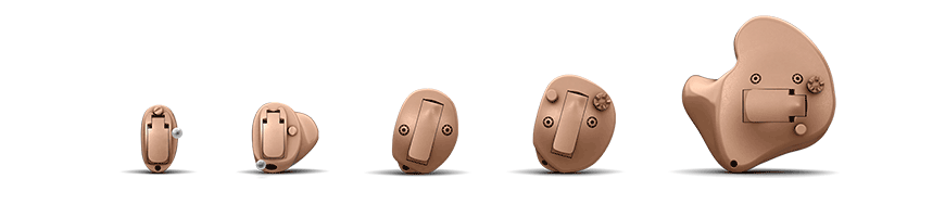 diferentes tipos de audífonos intraauriculares (ITE) alineados de menor a mayor tamaño