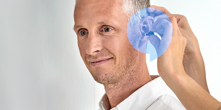 detalle de un hombre de perfil poniéndose los nuevos audífonos audika blink air