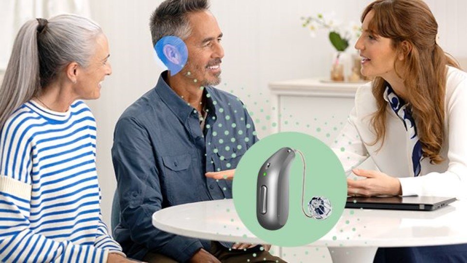 pareja senior en consulta con audioprotesista de Audika. Se ve un audifono avanzado