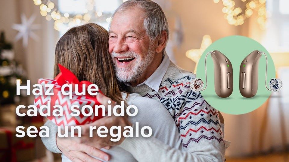 abuelo abrazando a su nieta con regalo de unos audifonos en la mano