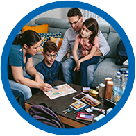 familia interactuando en una sala con materiales educativos sobre la mesa
