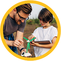 niño con audífonos aprendiendo sobre energía renovable junto a su padre
