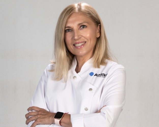 Audioprotesista Audika Alexandra Martínez con bata blanca y brazos cruzados