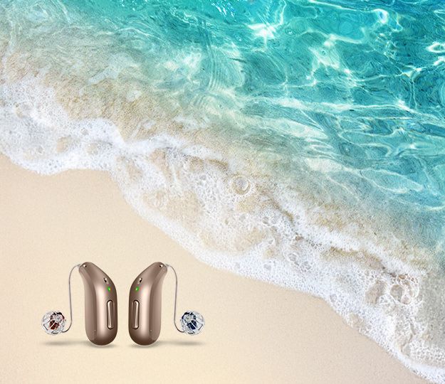 audífonos avanzados para tratamiento de tinnitus frente a un fondo de playa con agua cristalina