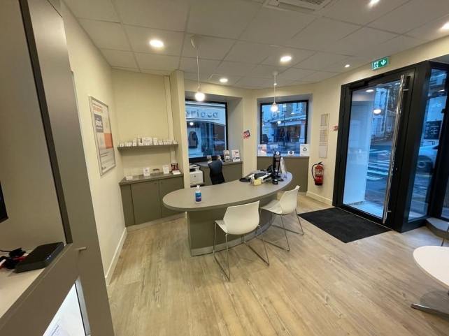 Intérieur moderne et accueillant du centre de soin auditif Audika Dinard avec espace de réception et meubles contemporains.