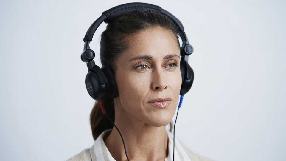 Une femme effectue un test auditif avec un casque dans un centre Audika.