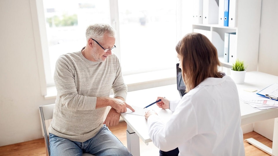 Un patient en rendez-vous avec un audioprothésiste pour faire un choix sur son appareil auditif