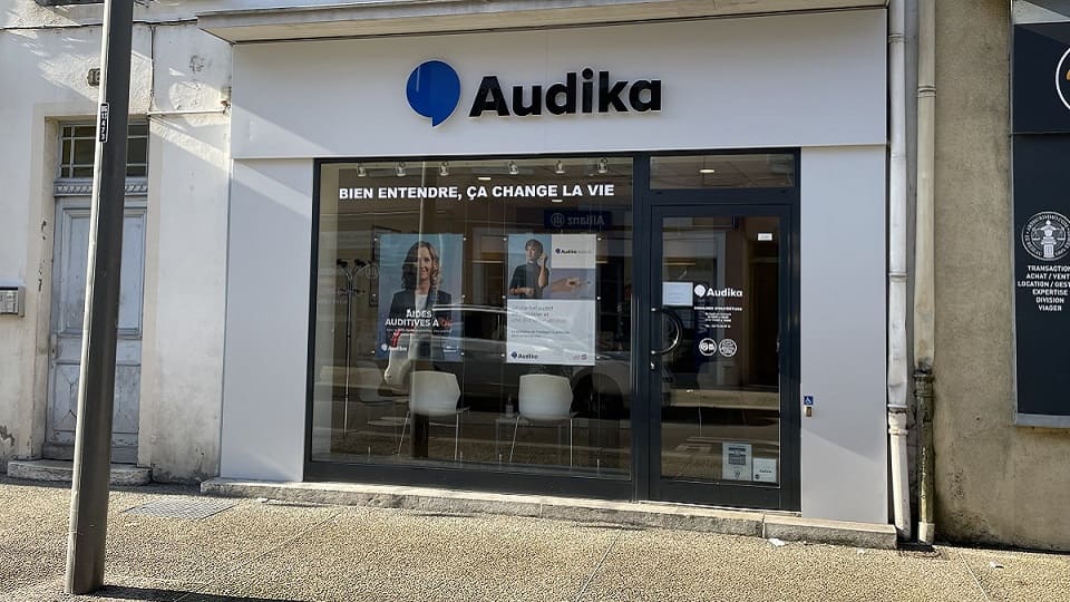 Façade du centre auditif Audika à Bourg-en-Bresse avec slogan « Bien entendre, ça change la vie ».