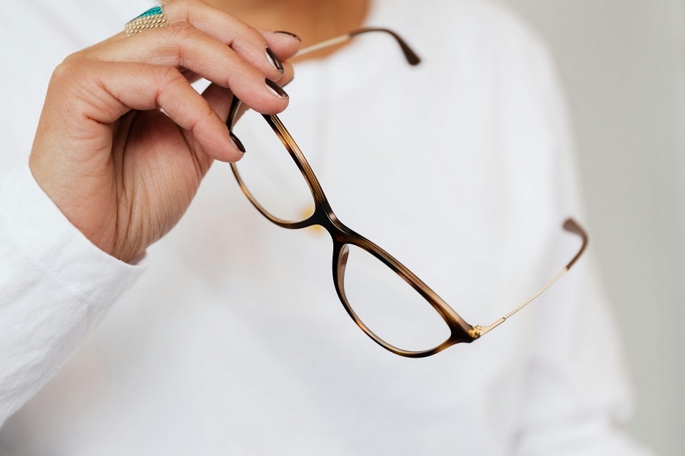 Une paire de lunette tenue dans une main